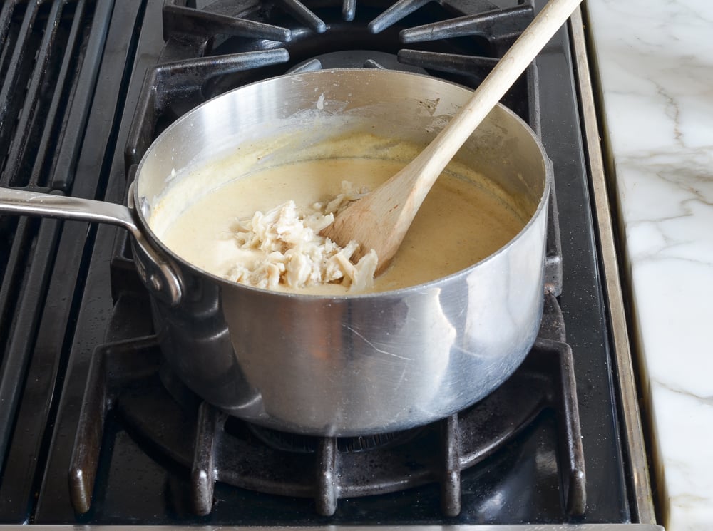 Crabmeat in a pot with a half and half mixture.