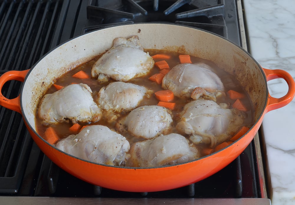 Carrots in a skillet with chicken.