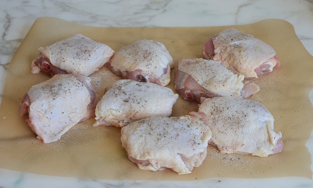 Seasoned chicken on parchment paper.