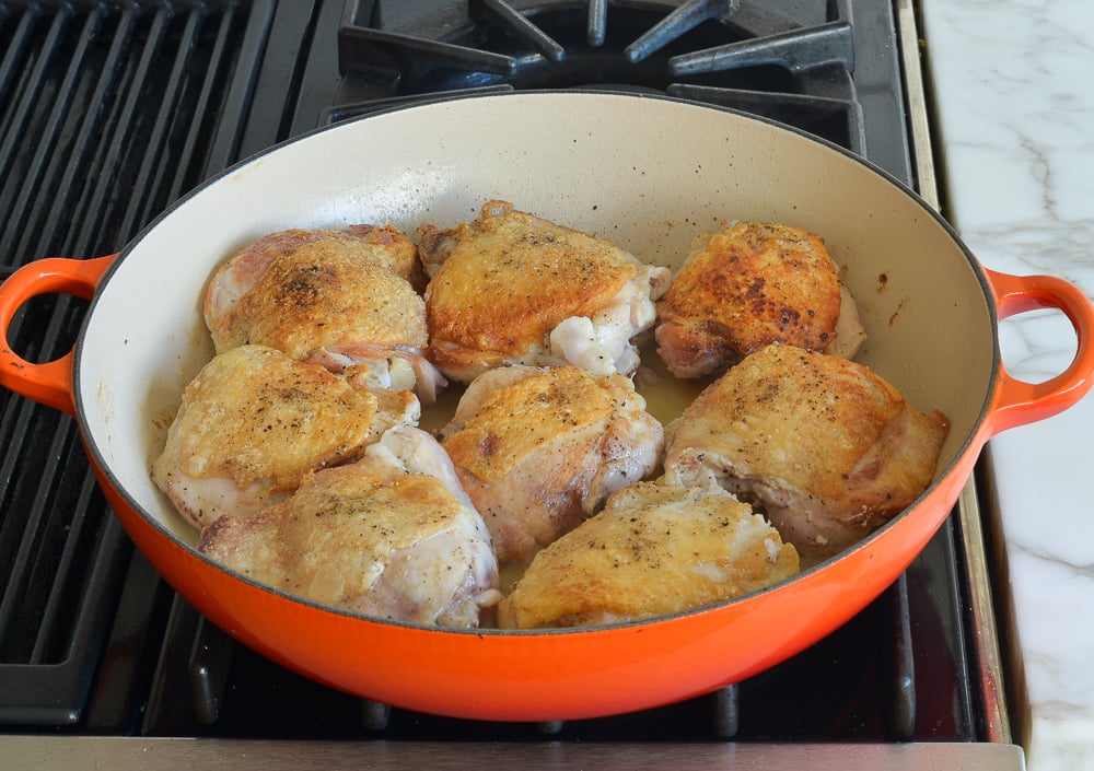 Seasoned chicken in a skillet.