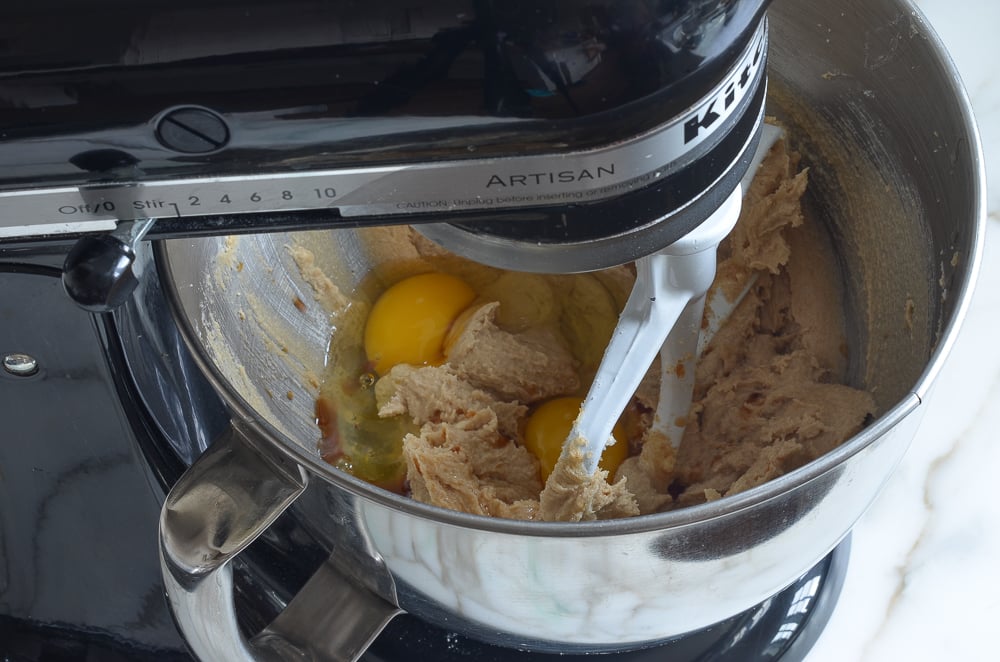 Eggs in a stand mixer with a butter mixture.