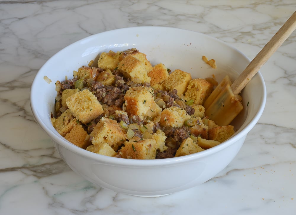 mixing all of the components for cornbread stuffing in a bowl 