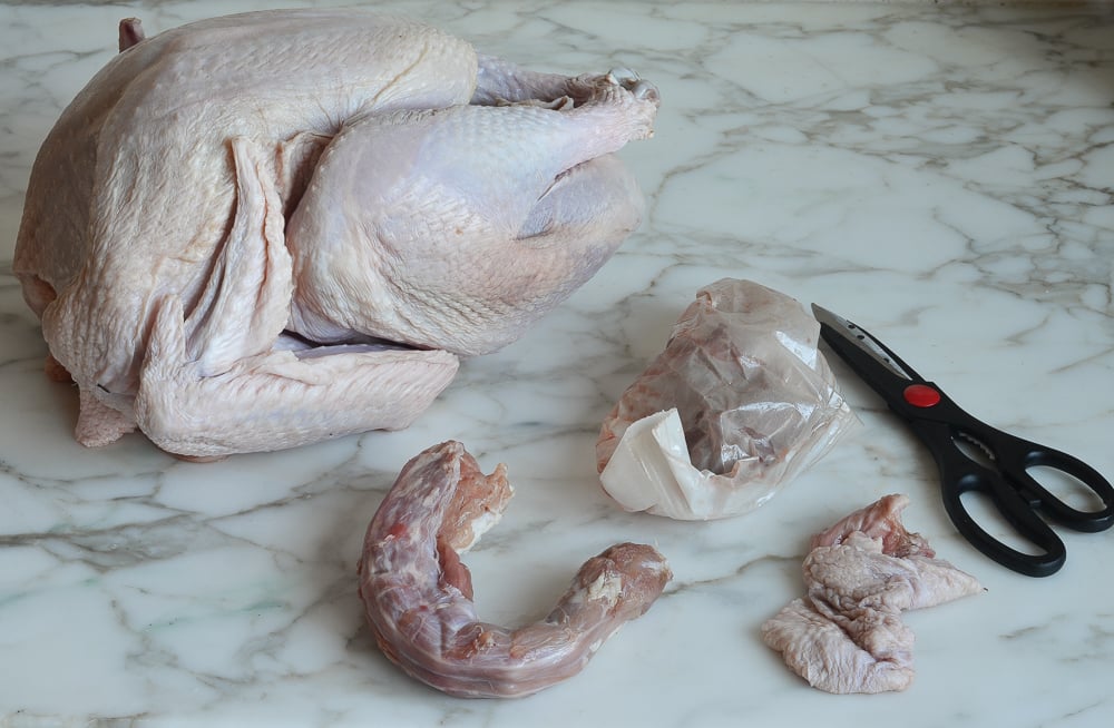 Turkey giblets and neck next to a turkey.
