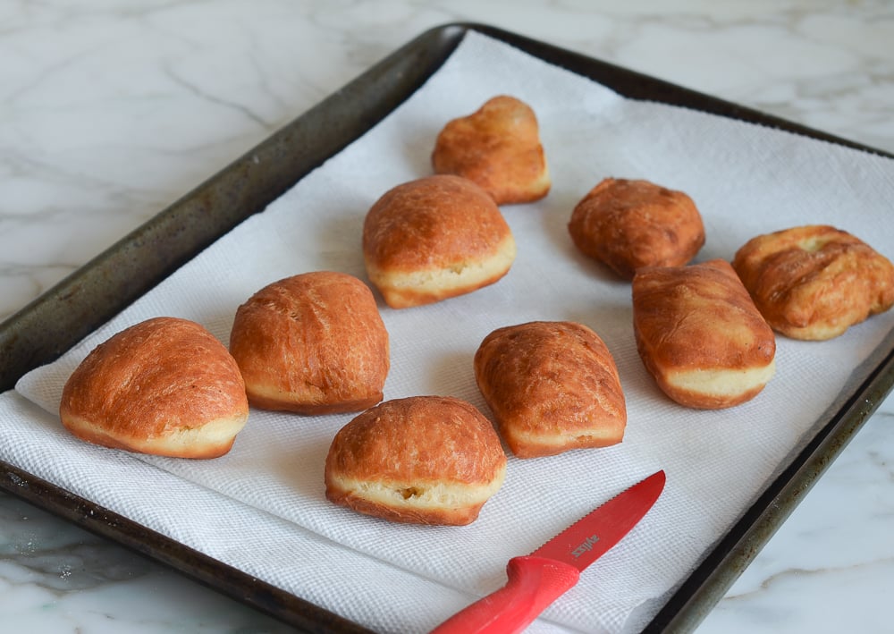 Lined baking sheet of donuts.