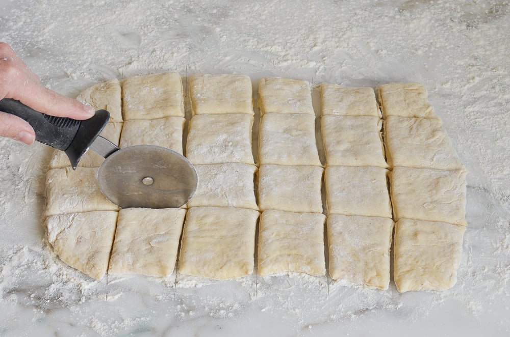 Pizza cutter slicing dough