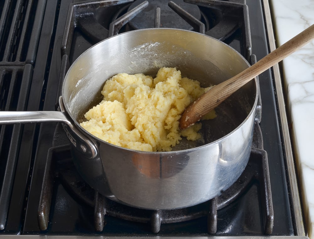 Ball of dough in a pan with a wooden spoon.