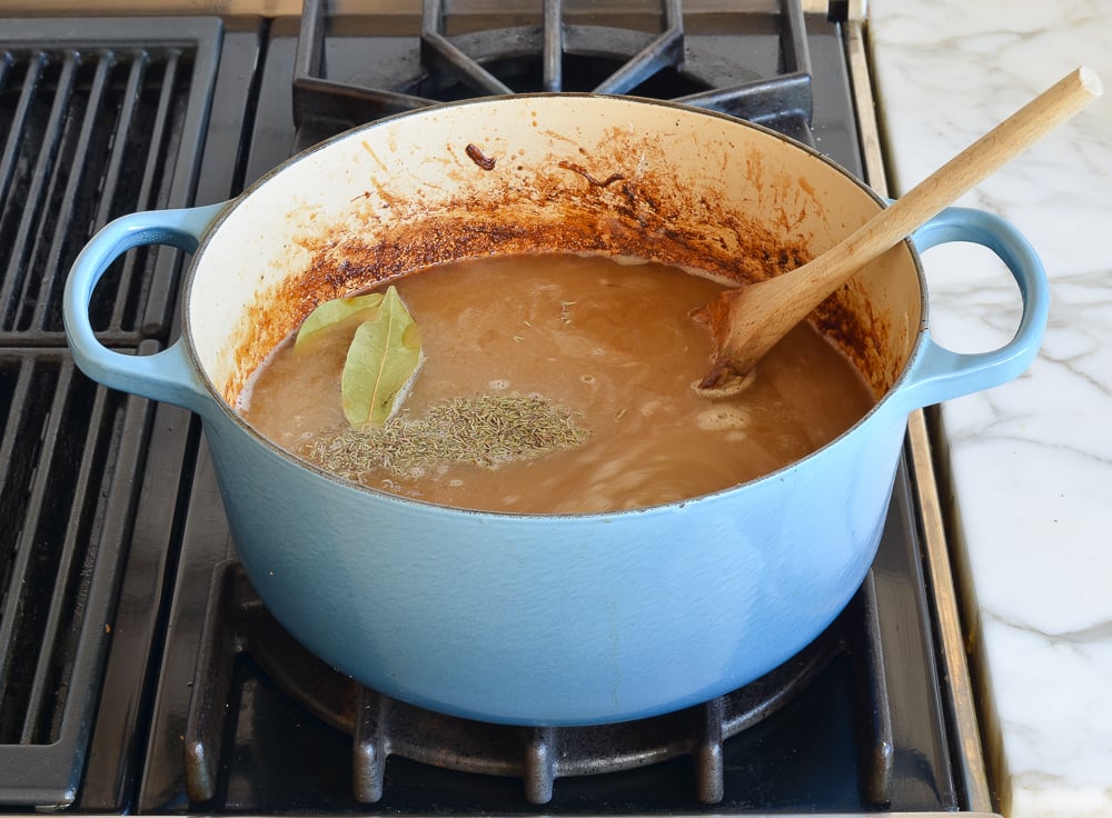 Broth, Worcestershire sauce, thyme, and bay leaves added to the pot.