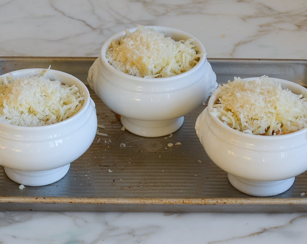 French onion soup crocks on baking sheet.