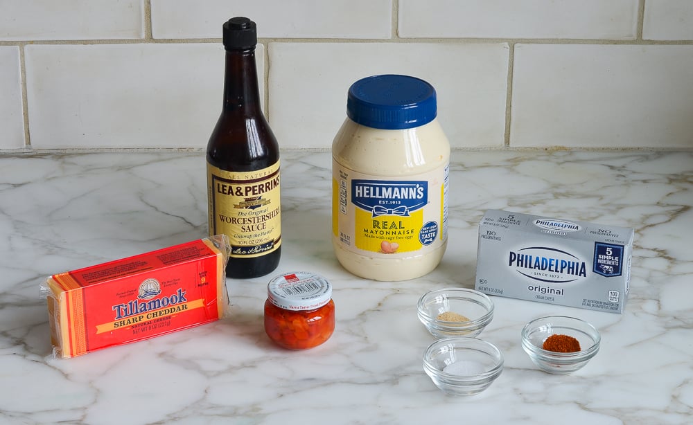 Pimento cheese ingredients including mayonnaise, cream cheese, and Worcestershire sauce on the table. 
