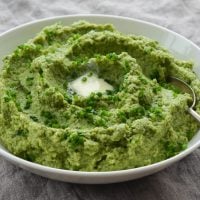 Spoon in a bowl of broccoli puree.