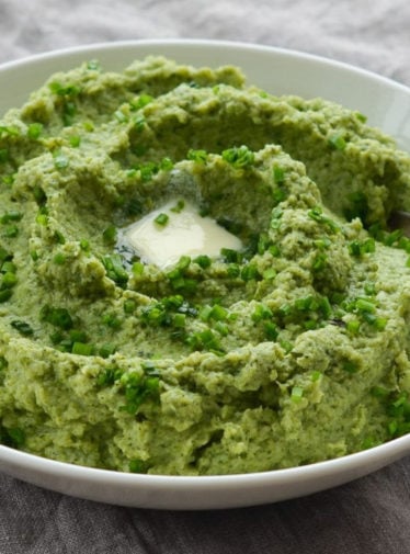 Spoon in a bowl of broccoli puree.