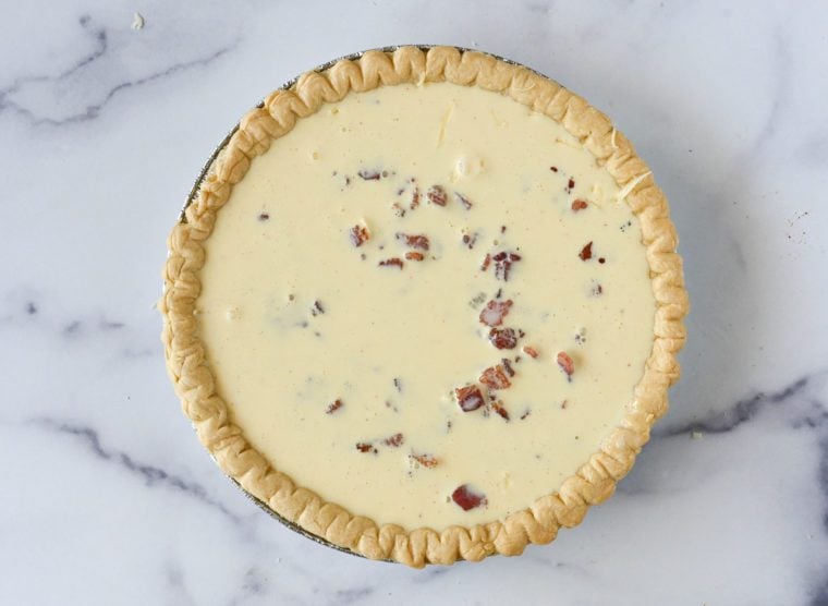 Pie crust full of and egg mixture.