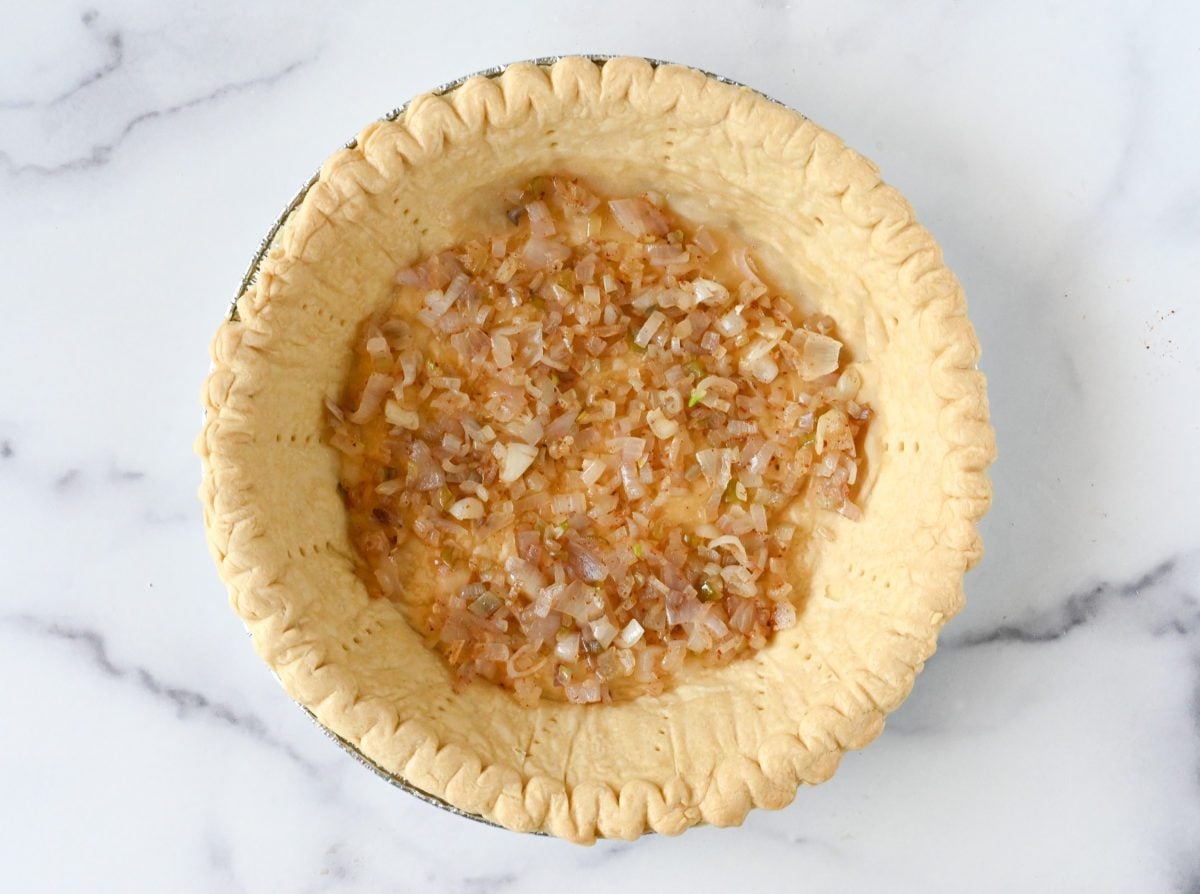 Shallots on the bottom of a pie crust.