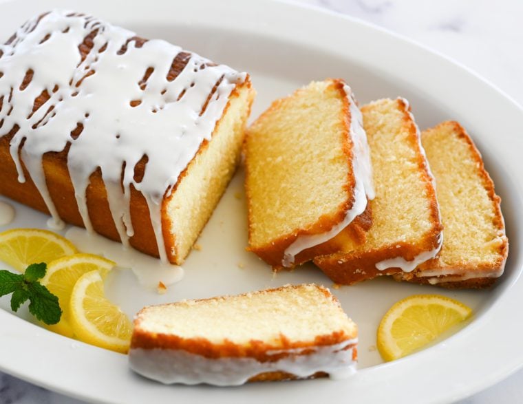 Partially sliced lemon pound cake on a plate.