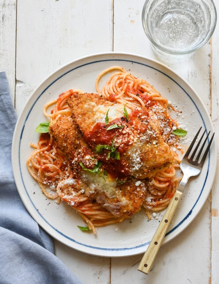 Chicken parmesan on a plate with a fork.