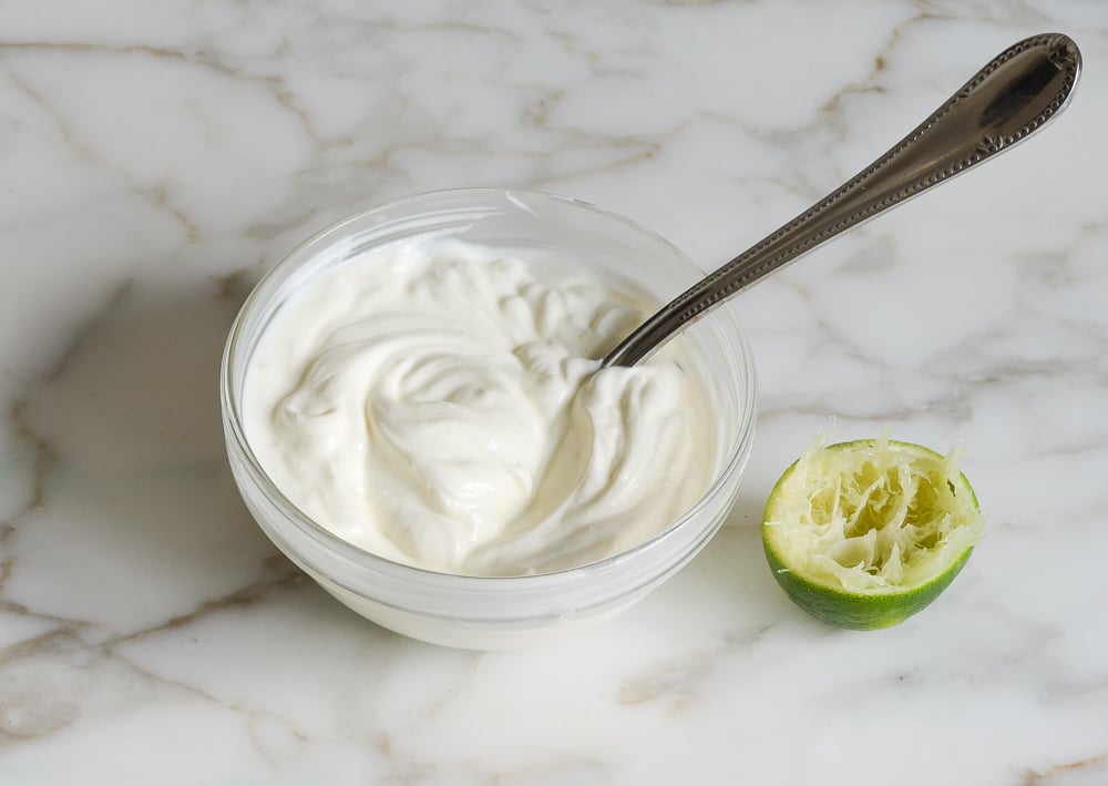 Stirring sour cream and lime to make lime crema
