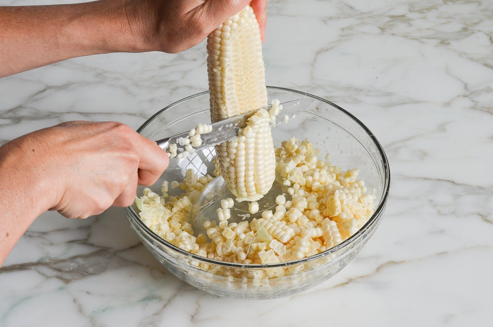 cutting the kernels off the corn cobs