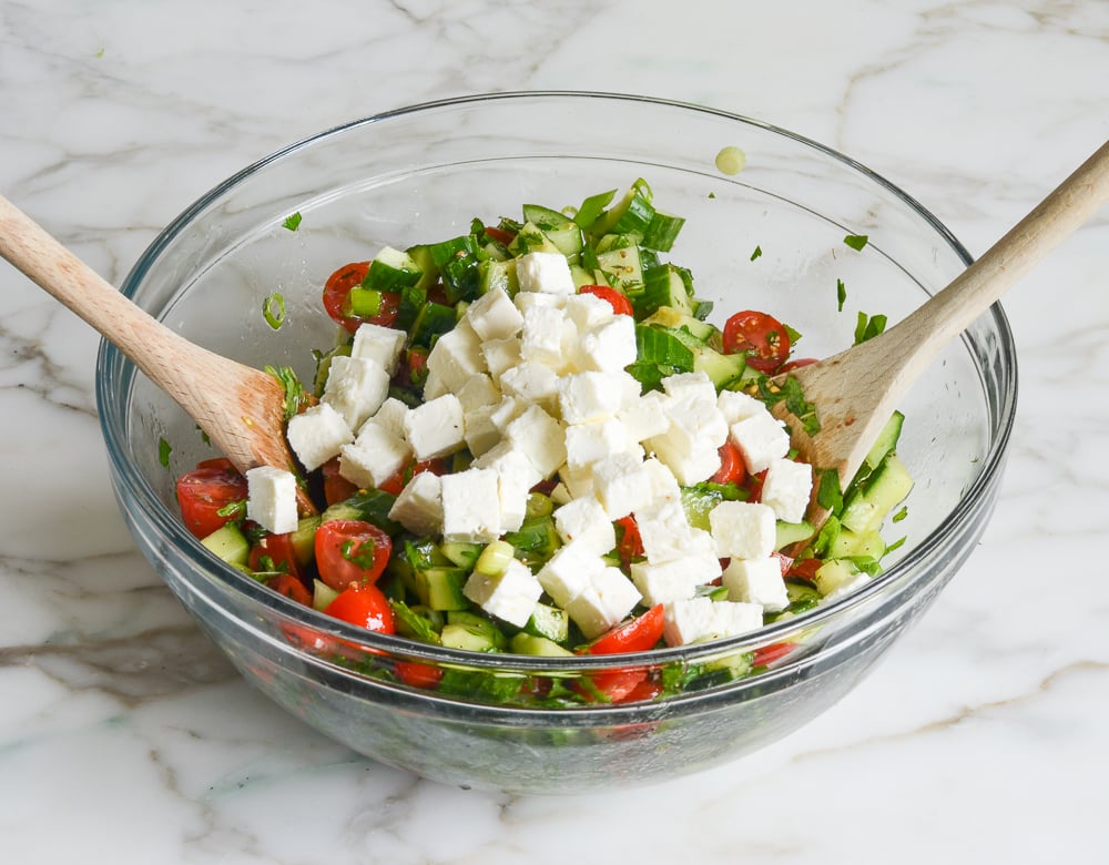 adding diced feta to vegetables