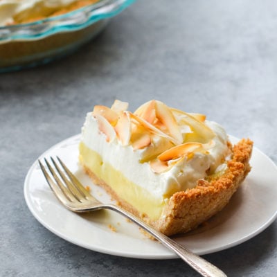 Fork on a plate with a slice of coconut cream pie.