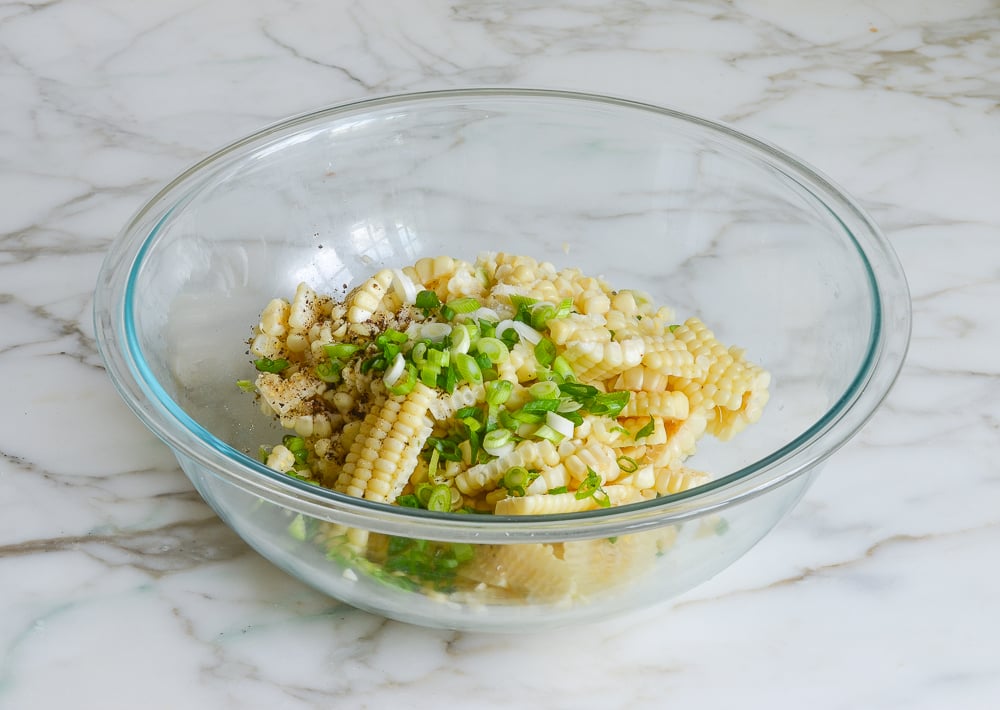 adding the dressing to the corn salad