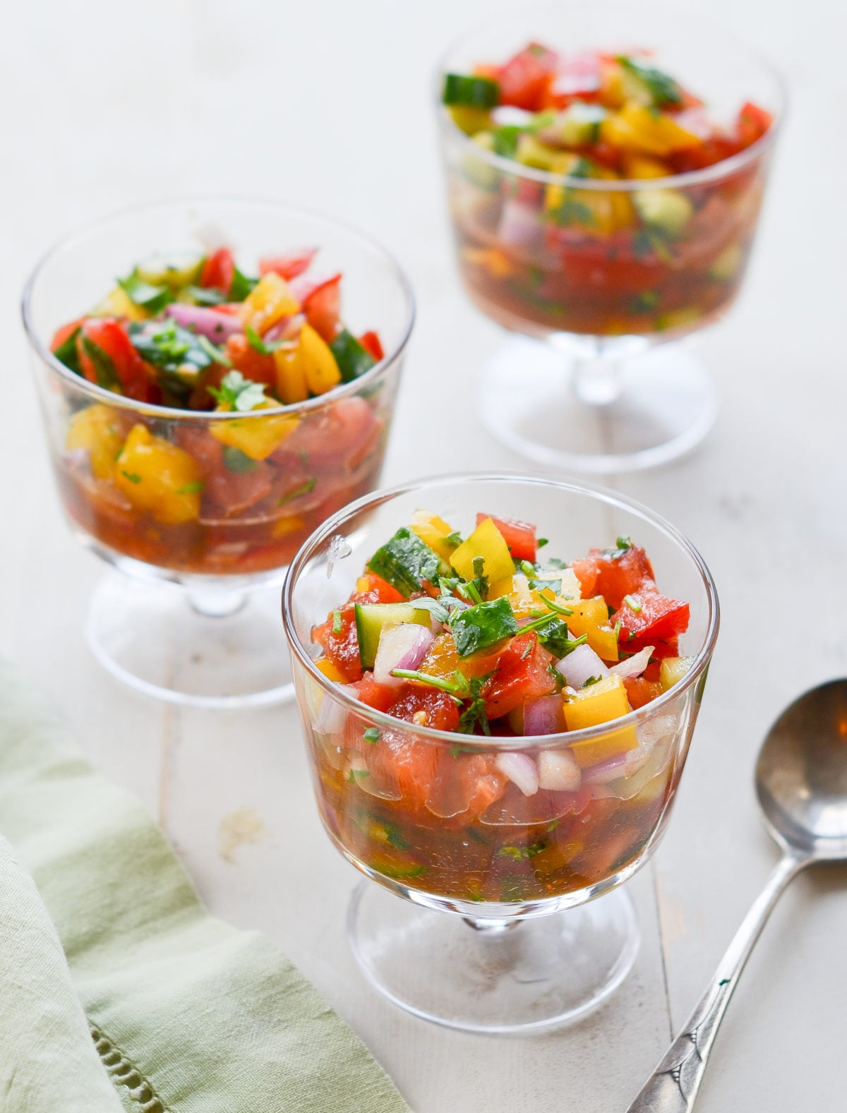 Three stemmed glasses of summer gazpacho salad.