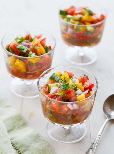 Three stemmed glasses of summer gazpacho salad.