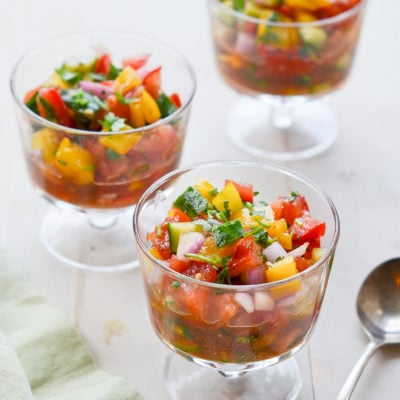 Three stemmed glasses of summer gazpacho salad.
