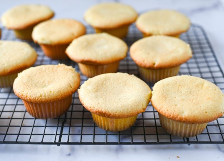 vanilla cupcakes cooling on rack