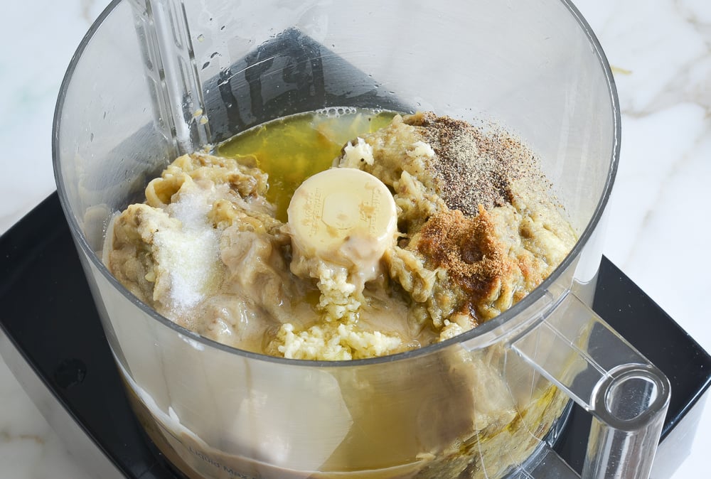 eggplant and other ingredients for baba ganoush in food processor bowl