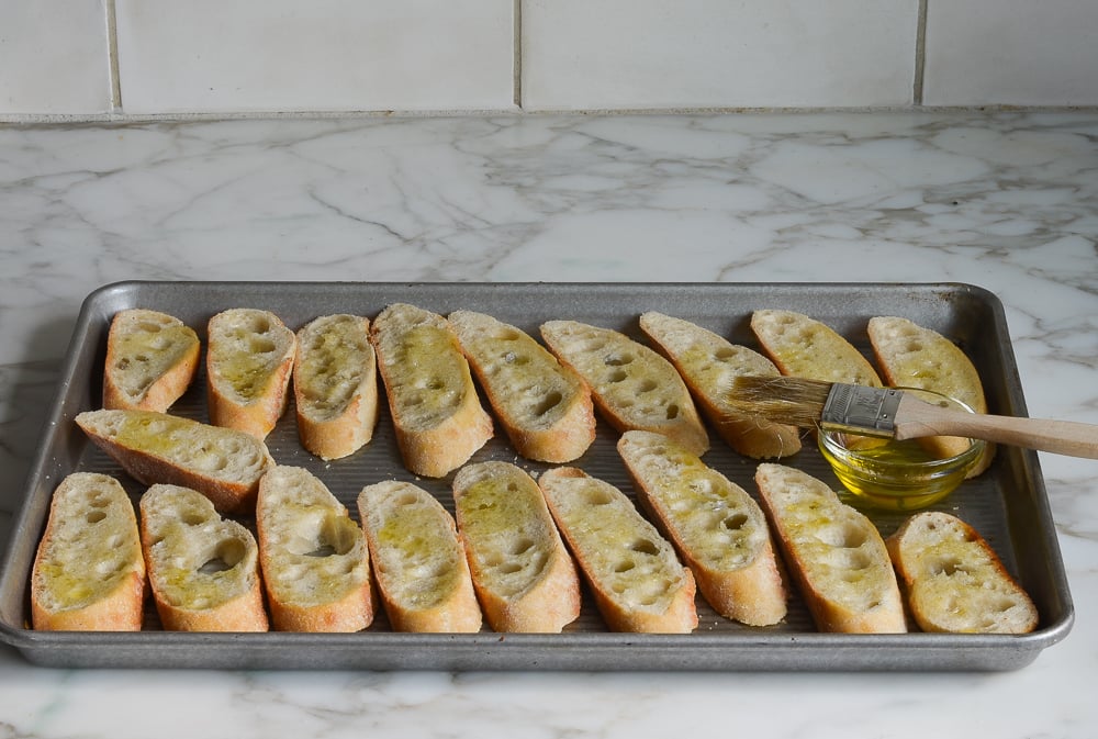 brushing the bread slices with olive oil