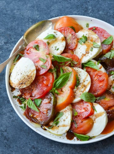Spoon on a plate with caprese salad.