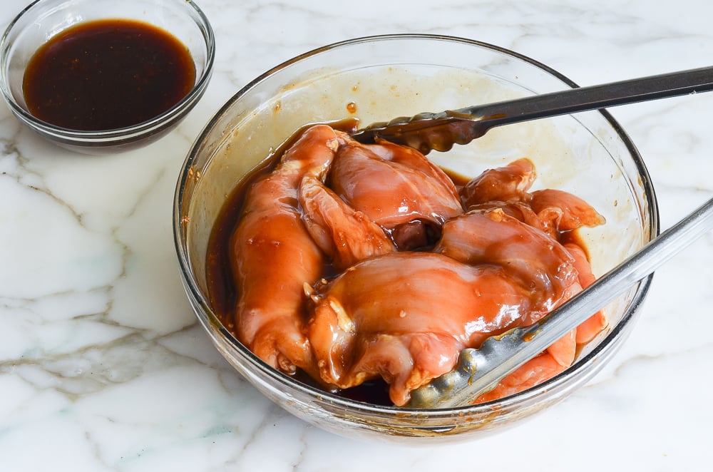 tossing the chicken with the marinade