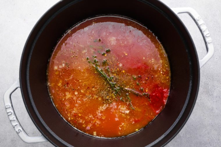 adding tomatoes, clam juice, water, sugar, herbs, and seasoning