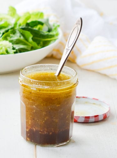 Glass jar of zesty homemade Italian dressing.