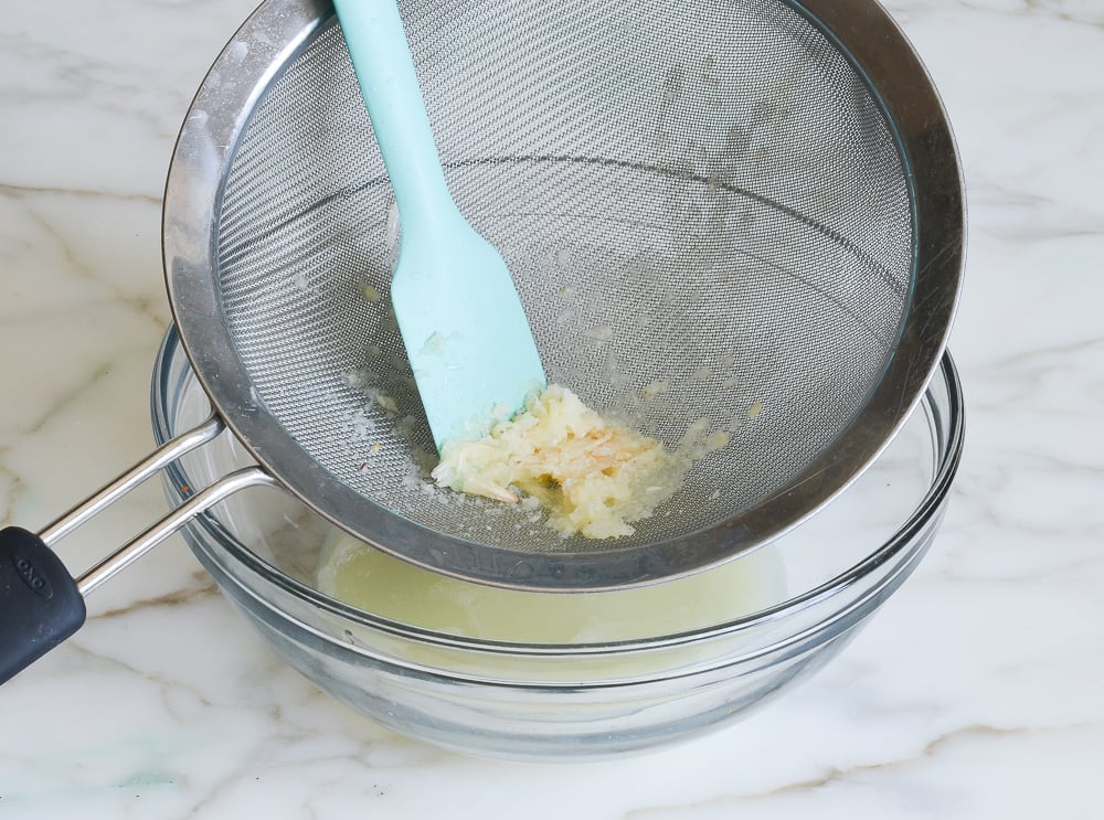straining lemon and garlic mixture