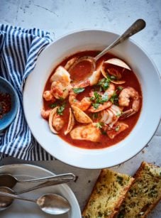 Bowl of cioppino with bread.