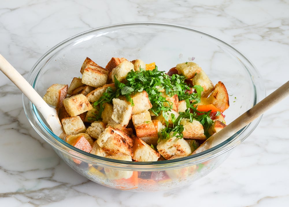 adding toasted bread and basil to mixing bowl