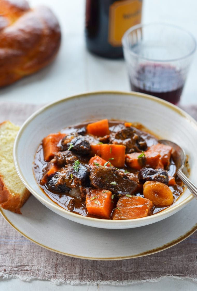 Spoon in a bowl of beef tzimmes.