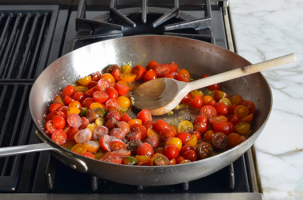 adding the cherry tomatoes, salt and pepper to the garlic