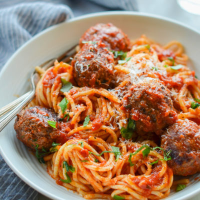 Fork in a bowl of spaghetti and meatballs.