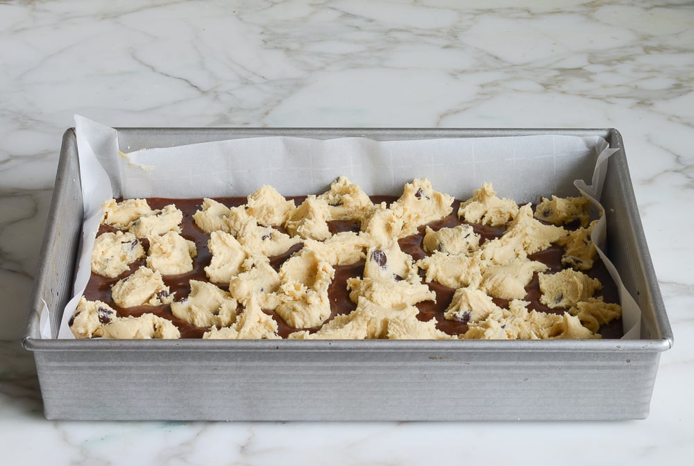 cookie batter dotted over brownie batter