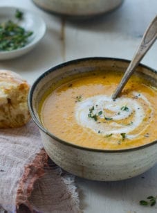 Spoon in a bowl of pumpkin soup.