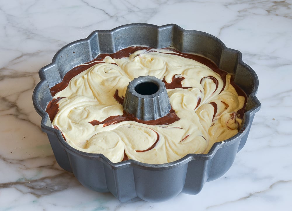 Swirled batter in a Bundt pan to make a marble bundt cake.
