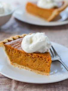 Slice of sweet potato pie on a plate with a fork.