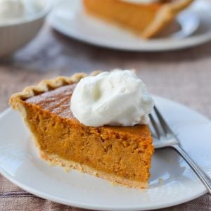 Slice of sweet potato pie on a plate with a fork.