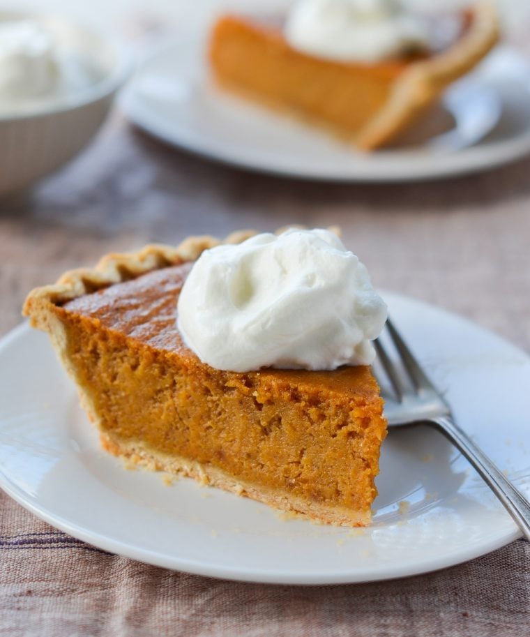 Slice of sweet potato pie on a plate with a fork.