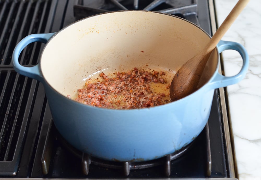 Pancetta cooking in a Dutch oven.