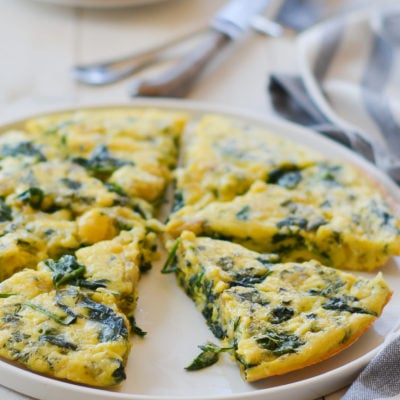 Sliced spinach frittata on a plate.