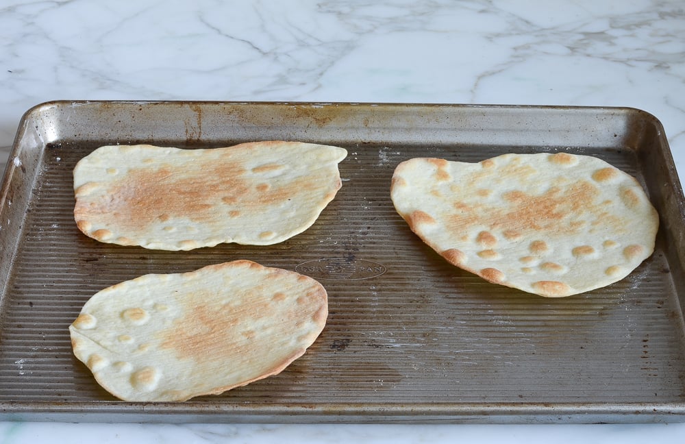 Cooked matzo on a baking sheet.