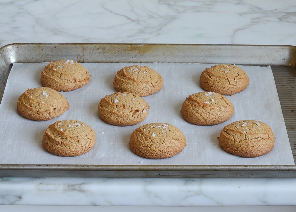 Flourless peanut butter cookies on a lined baking sheet.
